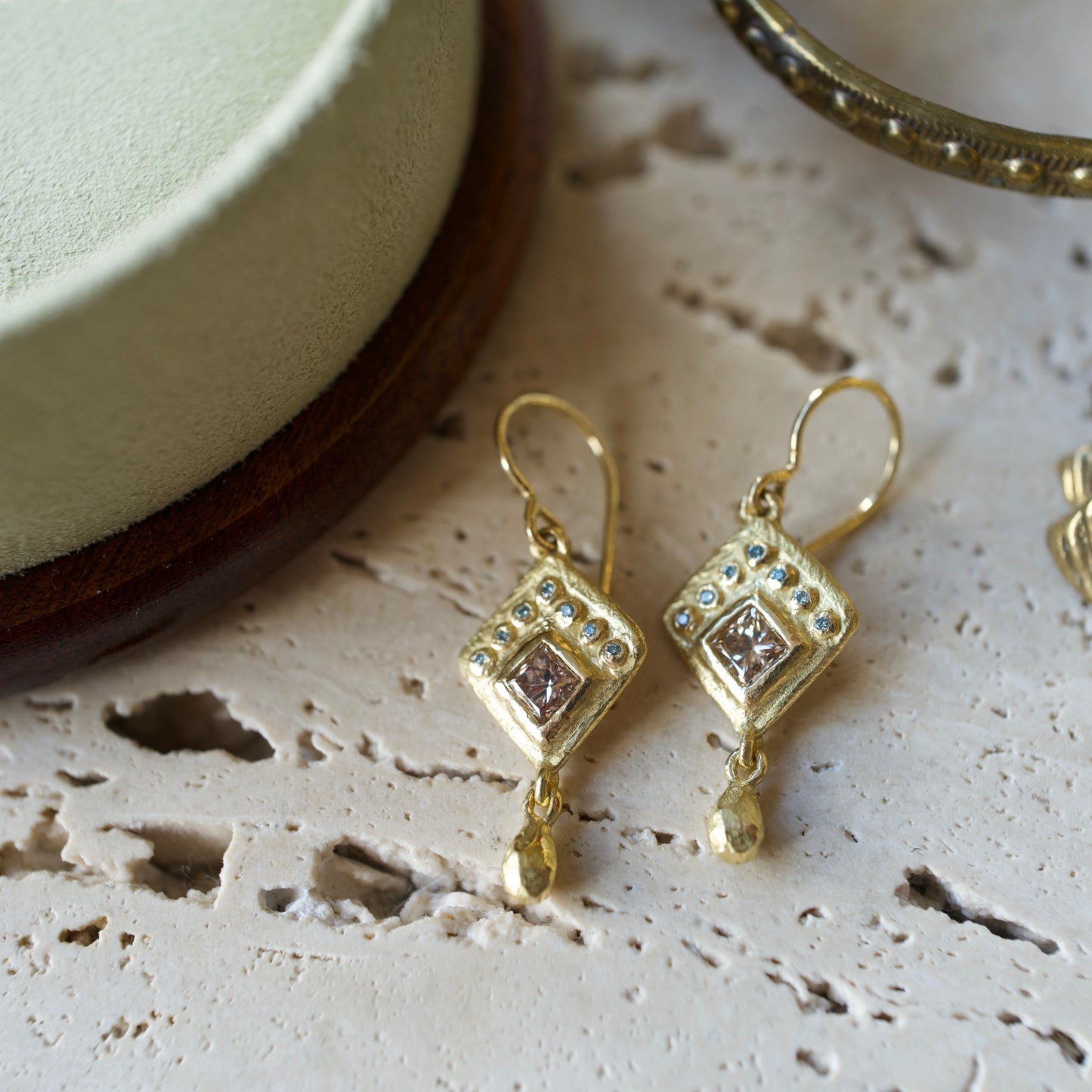 Handmade 18k gold earrings featuring cognac and blue diamonds. 
